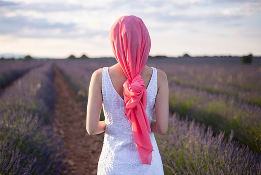 Woman with pink cancer scarf in a lavender field